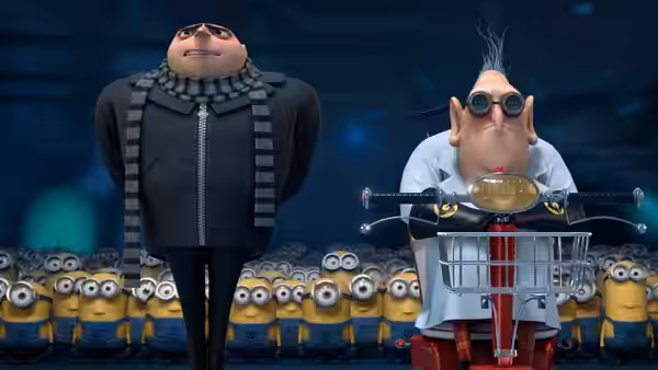 Gru (Steve Carell) stands beside Dr. Nefario (Russell Brand) before a crowd of Minions