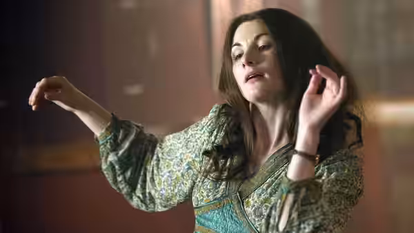 Ruth (Jodie Whittaker) dances with her arms raised indoors