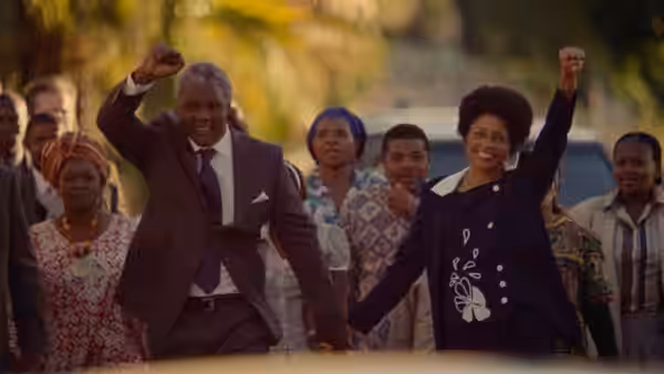 Nelson Mandela (Idris Elba) and Winnie Madikizela (Naomie Harris) raise their fists among supporters