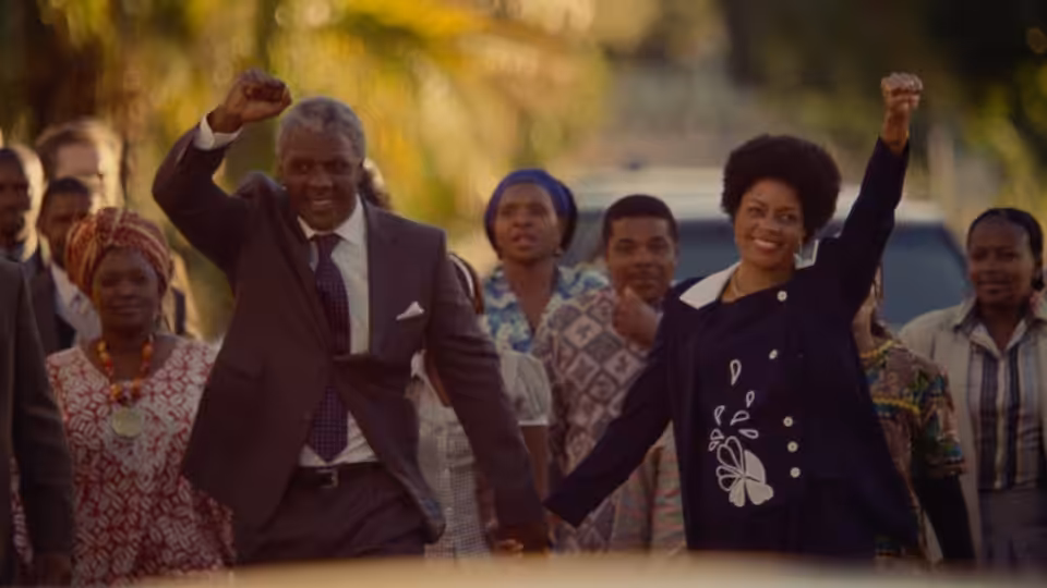Nelson Mandela (Idris Elba) and Winnie Madikizela (Naomie Harris) raise their fists among supporters
