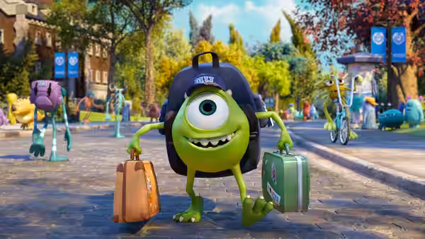 Mike Wazowski (Billy Crystal) arrives on campus carrying two suitcases as students pass