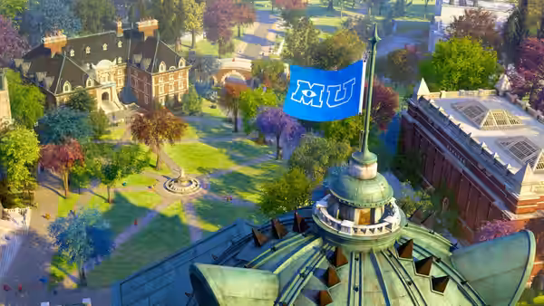 A Monsters University flag flies above the campus buildings and tree-lined courtyard