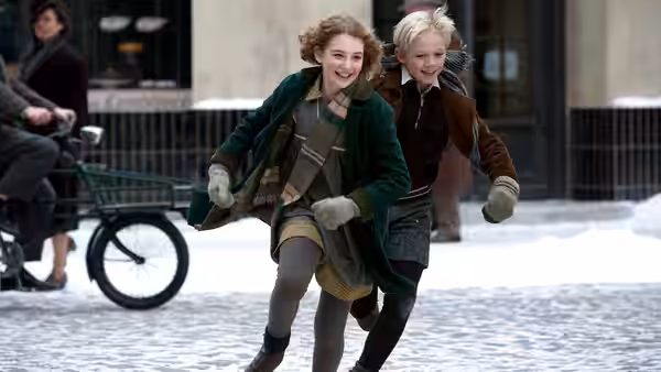 Liesel Meminger (Sophie Nélisse) and Rudy Steiner (Nico Liersch) run through a snowy street