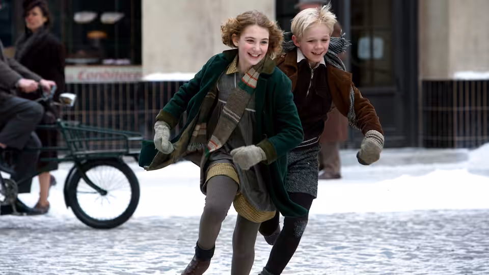Liesel Meminger (Sophie Nélisse) and Rudy Steiner (Nico Liersch) run through a snowy street