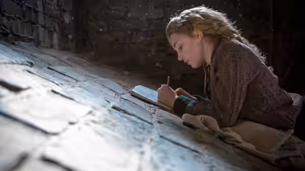 Liesel Meminger (Sophie Nélisse) writes in a book in the cellar