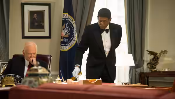 Cecil Gaines (Forest Whitaker) arranges papers on the desk as President Nixon sits nearby