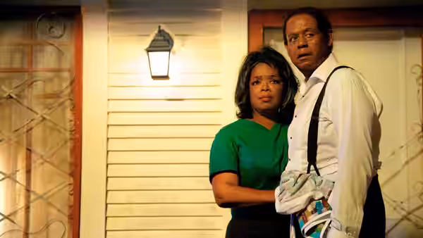 Gloria Gaines (Oprah Winfrey) and Cecil Gaines (Forest Whitaker) stand together outside their home