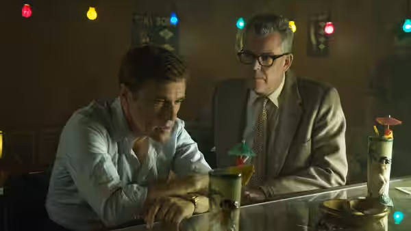 Walter Keane (Christoph Waltz) sits at a bar beside Dick Nolan (Danny Huston)
