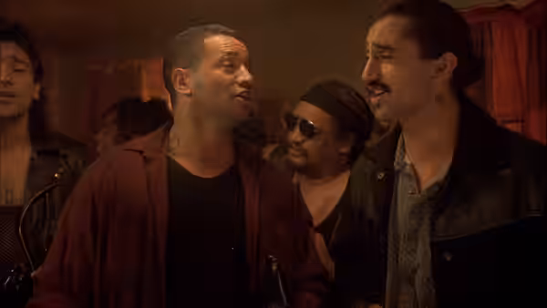 Jake Heke (Temuera Morrison) talks with two men inside a dimly lit room