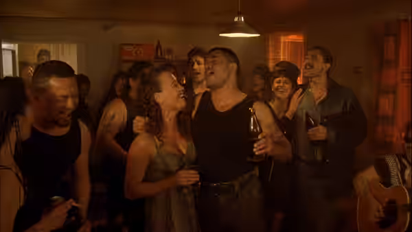 Jake Heke (Temuera Morrison) sings with arm around Beth Heke (Rena Owen) at a party