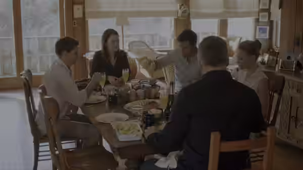 A family gathers around a dining table for a meal