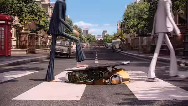 A Minion lies beneath a flower-filled sidewalk grate as pedestrians walk past