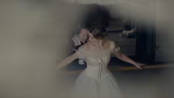Lili (Eddie Redmayne) wears a white gown as Gerda (Alicia Vikander) helps her pose