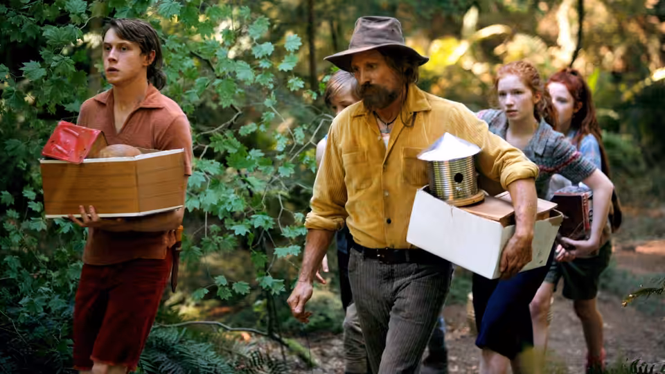 Ben Cash (Viggo Mortensen) leads his children through the forest as they carry boxes and supplies