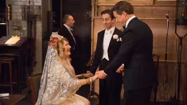 Florence Foster Jenkins (Meryl Streep) sits in bridal dress as St. Clair Bayfield (Hugh Grant) takes her hand