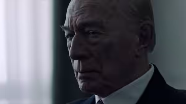 Jean Paul Getty (Christopher Plummer) looks ahead in a dark suit beside a window