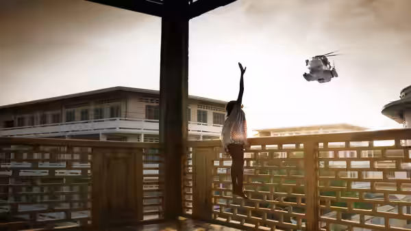 A girl waves toward a helicopter hovering beyond a balcony