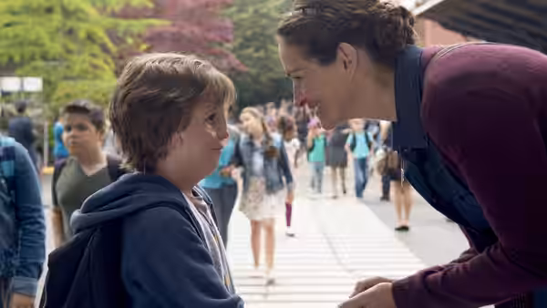 Isabel (Julia Roberts) leans toward Auggie (Jacob Tremblay) outside the school