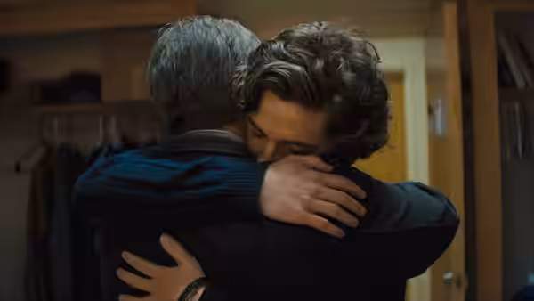 Nic embraces David in a doorway
