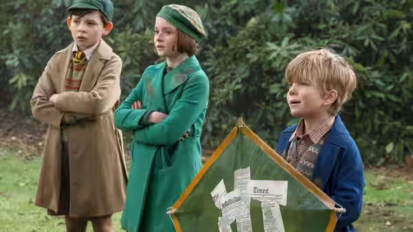 Annabel, John and Georgie Banks stand together in a garden beside a small green tent