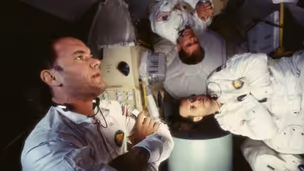 Astronauts in white suits floating inside the spacecraft interior