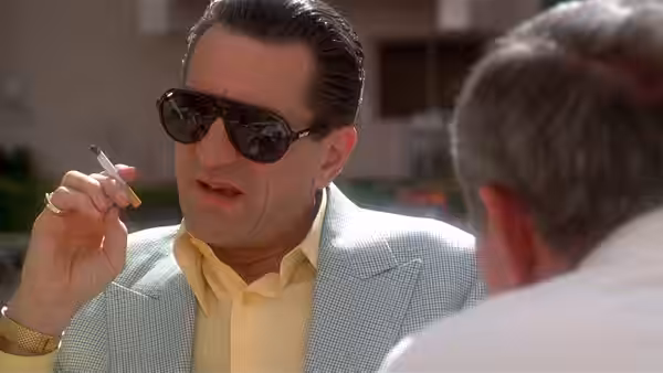 Sam 'Ace' Rothstein (Robert De Niro) holding a cigarette while talking to another man