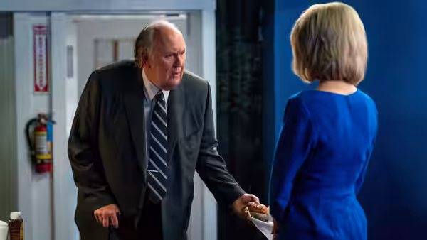 Roger Ailes (John Lithgow) speaks with Megyn Kelly (Charlize Theron) in a doorway