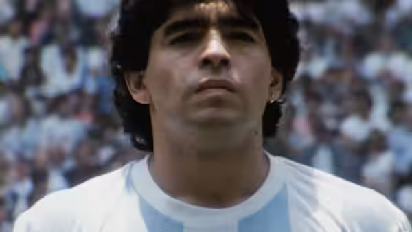 Diego Maradona stands in Argentina's striped jersey before a packed stadium