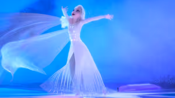 Elsa (Idina Menzel) stretches her arms as sparkling magic streams from her gown