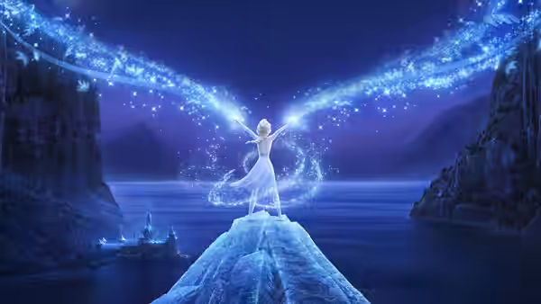 Elsa (Idina Menzel) raises her arms on an icy promontory as sparkling magic arcs overhead