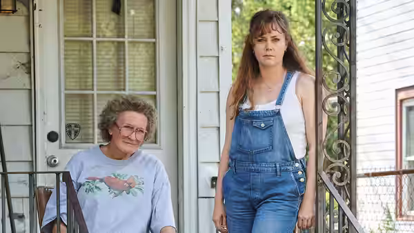 Mamaw (Glenn Close) sits on the porch beside Bev (Amy Adams)
