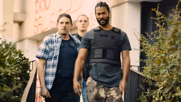 Gwada (Djebril Zonga) walks through the neighborhood with Chris (Alexis Manenti) and another officer