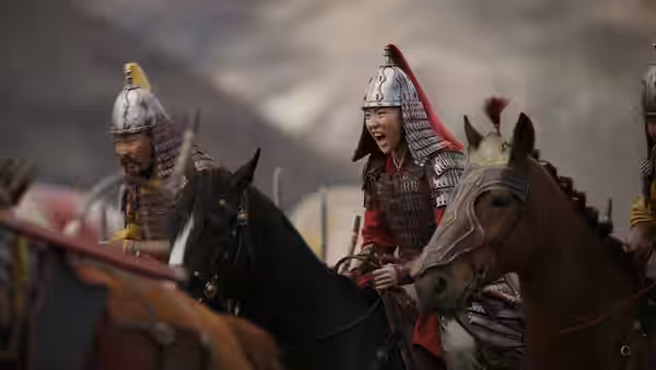 Hua Mulan (Liu Yifei) rides with fellow soldiers through the battlefield