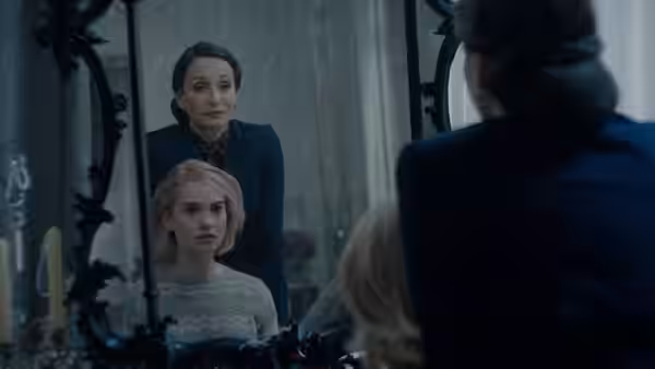 Mrs. Danvers (Kristin Scott Thomas) stands behind Mrs. de Winter (Lily James) at a mirror