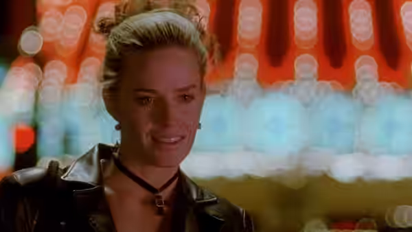 Sera (Elisabeth Shue) smiling against blurred neon city lights