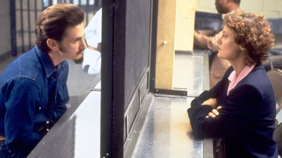 Matthew Poncelet (Sean Penn) and Sister Helen Prejean (Susan Sarandon) talking through a prison partition
