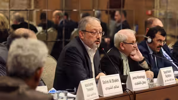 Jamal Khashoggi speaks at a panel table beside other delegates