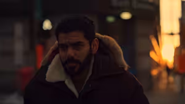 Omar Abdulaziz walks along a dimly lit city street