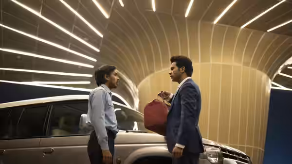 Balram (Adarsh Gourav) faces Ashok (Rajkummar Rao) beside a parked car, holding a red bag