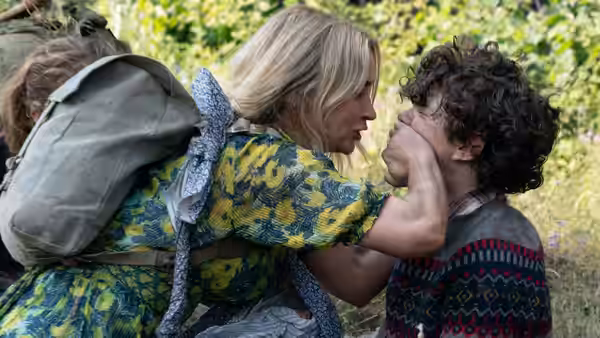 Evelyn Abbott (Emily Blunt) grips Marcus Abbott's (Noah Jupe) face outdoors