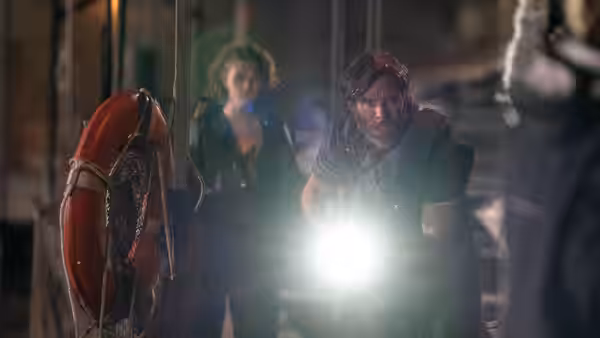 Emmett (Cillian Murphy) searches a room with a flashlight as Regan Abbott (Millicent Simmonds) follows