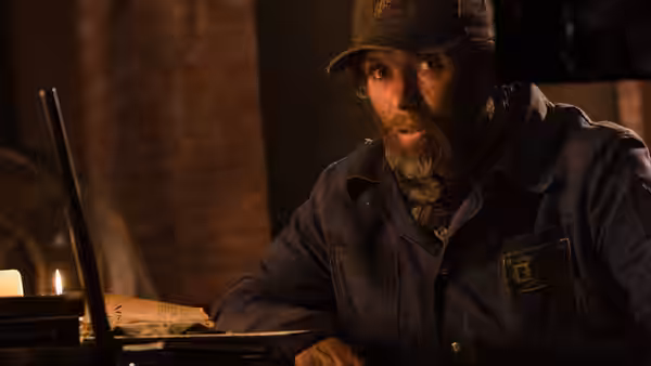 Emmett (Cillian Murphy) sits at a table in a dimly lit room