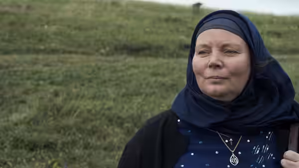 Mary (Joanna Scanlan) stands in a grassy field