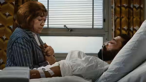Emmi Kurowski (Brigitte Mira) holds Ali's hand beside his hospital bed