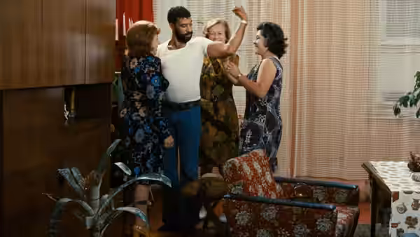 Emmi Kurowski (Brigitte Mira), Ali (El Hedi ben Salem), and two women celebrate together in a living room
