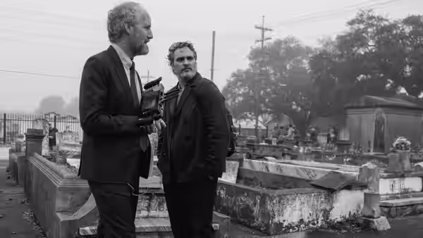 Johnny (Joaquin Phoenix) speaks with an older man among rows of graves