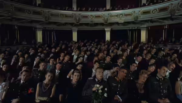 a large audience seated in an ornate theater auditorium