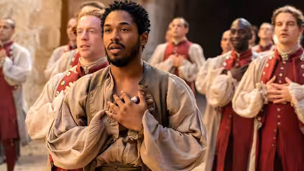 Christian (Kelvin Harrison Jr.) stands with clasped hands before a gathering of soldiers