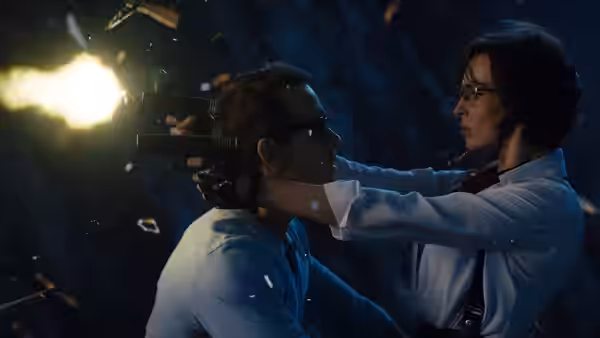 Millie (Jodie Comer) points a gun at Guy (Ryan Reynolds) in a dark, debris-filled setting