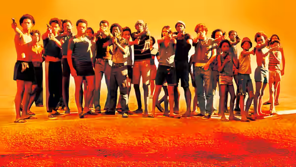 Large group of young people aiming guns at sunset